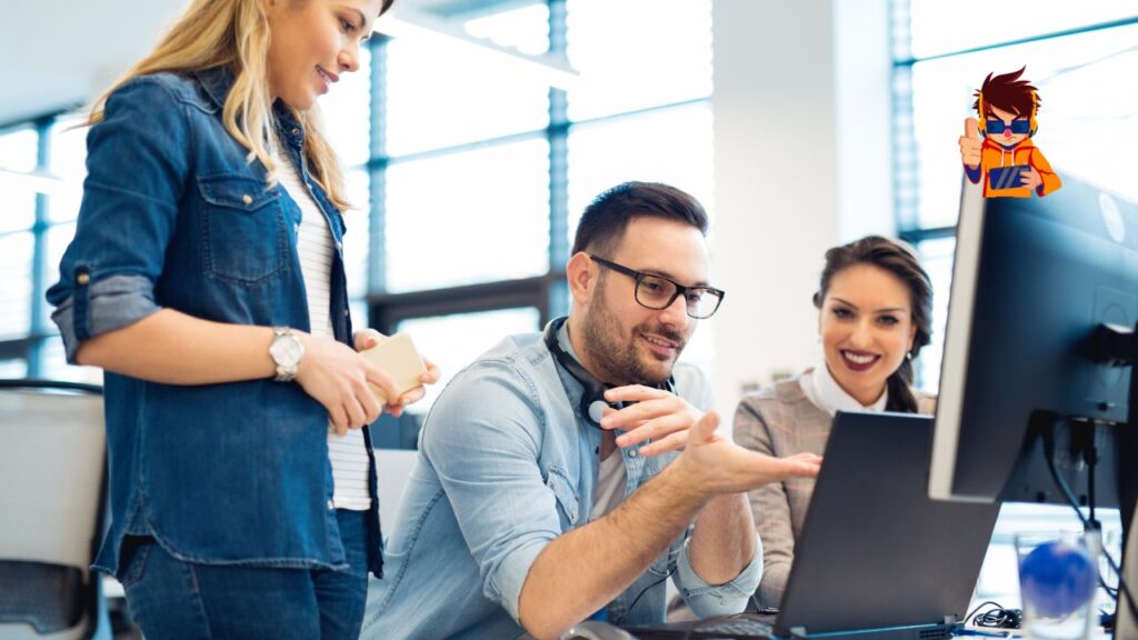Group of three young professionals collaborating in front of a computer in a modern office.